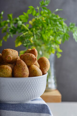 Buñuelos de bacalao con perejil caseros servidos con una fuente de porcelana.