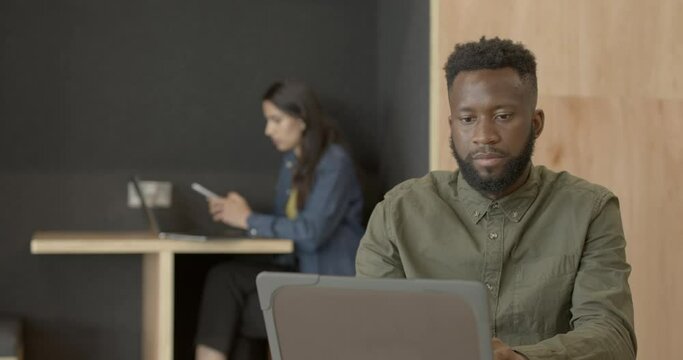 Afro American Business man working in office on laptop being focused