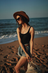 pretty woman in hat walking on the beach ocean travel