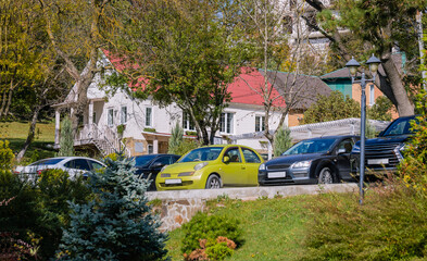 Cars are parked near the house in the parking lot.