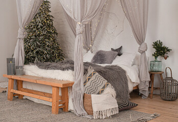 Christmas decorated rustic wooden bedroom interior in gray, white, silver colours with big baldaquin bed, fake fur blanket, candles, Christmas fir tree and gifts on floor. Christmas morning  © somegirl