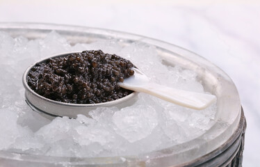 caviar in a metal tin with a mother-of-pearl spoon