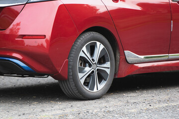 Fototapeta na wymiar Red car. Car wheels close up on a background of asphalt.