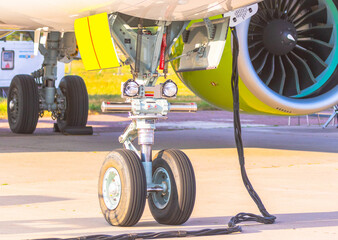 the jet is on ground service at the airport, the landing gear and the engine of the aircraft