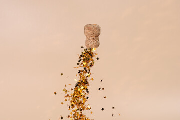 champagne stopper with a trail of gold candy in the shape of sparkling stars. Trendy image on a...