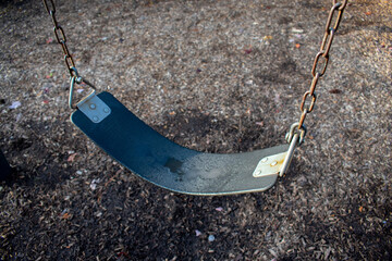 Playground swing set with water on the seat from rain or dew