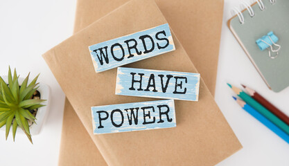 The words Words Have Power written in 3d wooden alphabet letters isolated on an orange background with copy space