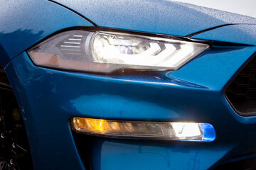 View of the front headlight of a blue sports car
