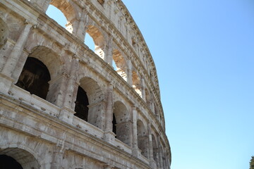 Fototapeta premium coliseum in rome italy showing old architecture in brown tones with blue sky, outside of coliseum