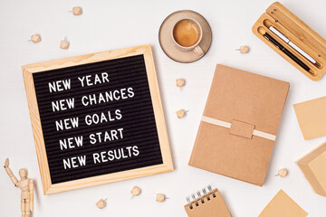 Letter board with motivation text new year, chances, goals, start, results. New year celebration and resolutions idea. Flat lay with message board, coffee, planner and pen