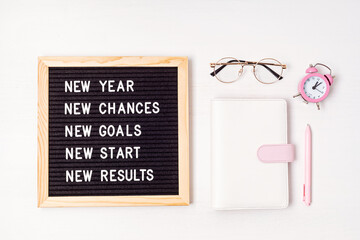 Letter board with motivation text new year, chances, goals, start, results. New year celebration and resolutions idea. Flat lay with message board, planner and pen