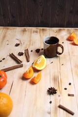 Cup of fruit coffee with spices on wooden table