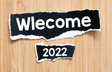 Welcome 2022 words on black sheets of paper.