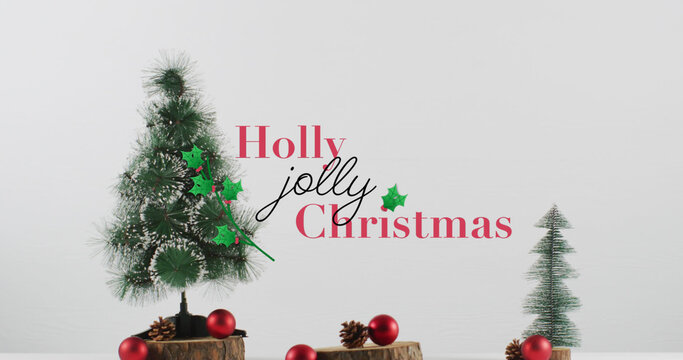 Image of holly christmas text over fir tree