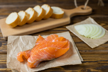 Smoked salmon sandwich with cream cheese on wooden table. top view
