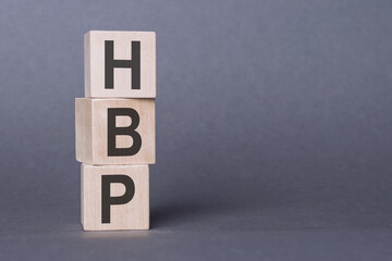 HBP - high blood pressure, text written on wooden blocks, on gray background.
