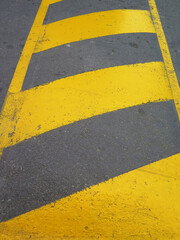 Fototapeta premium Yellow striped road markings on black asphalt