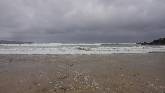 Waves Lapping Sand at Godrevy Beach in Cornwall on a Cloudy Day (Close-Up)