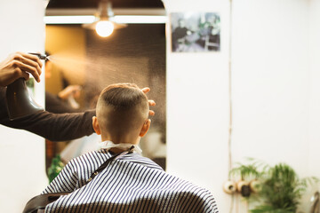 the boy gets a haircut in a barber shop