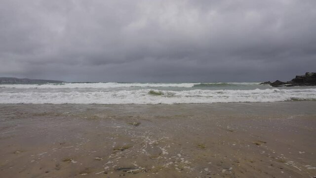 Waves Lapping Sand at Godrevy Beach in Cornwall on a Cloudy Day (Close-Up)