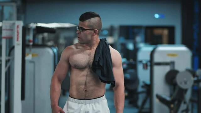 Muscular Arab in the gym is walking after a workout.