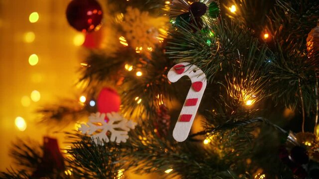 Closeup of colorful Chrsitmas ree garland lights, baubles and toys hanging on Christmas tree.