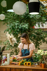 Florist woman making a bouquet of fresh flowers in a flower shop