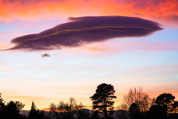A wispy, feather-like cloud adds whimsical interest to this colorful Colorado sunset.