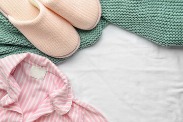 Slippers and pajamas on fabric background
