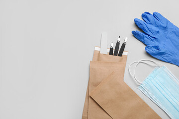 Medical masks, gloves and manicure kit on light background