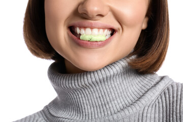 Young woman with chewing gum on white background, closeup