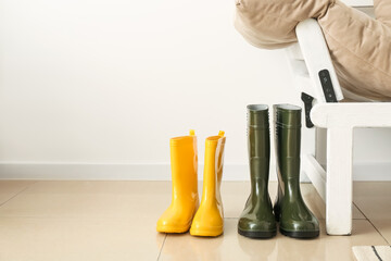 Rubber boots near white wall in hallway