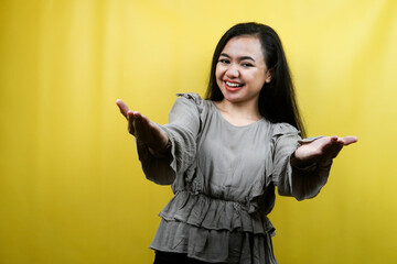 Beautiful young woman, with open arms, welcome, presenting something happily, isolated