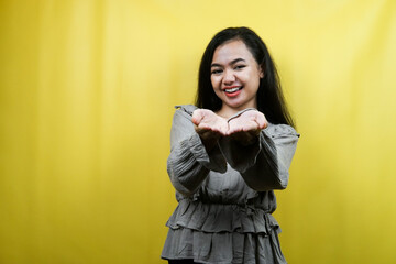 Beautiful young woman, with open arms, presenting something happily, isolated