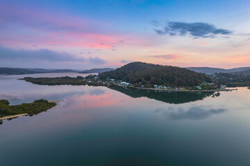 Soft and peaceful sunrise aerial waterscape with clouds and reflections
