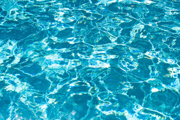Fototapeta na wymiar Water background, ripple waves. Blue swiming pool pattern. Sea surface. Water in swimming pool with sun reflection. Banner with copy space.
