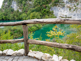 Wooden rail fence in front of teal blue lake in the Plitvice Lakes District, Croatia