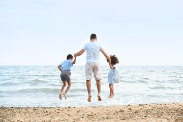 Fototapeta na wymiar Little children with father on sea beach