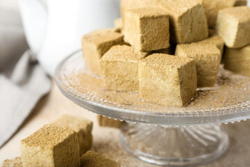 Stand with tasty hojicha marshmallows on light table, closeup