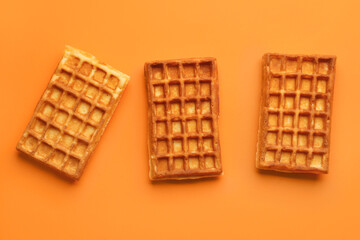 Delicious Belgian waffles on orange background