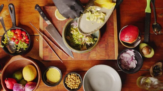 Preparation of Ceviche - table top view of a professional chef tossing and mixing fresh ingredients in a bowl, cooking scene concept.