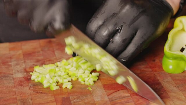 Professional chef meal prep, brunoise dice cut green capsicum for salad making and cooking.