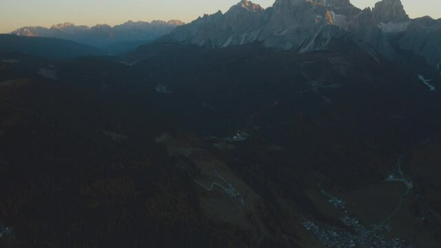 Aerial tilt up shot of Cima Unidici and Croda dei Toni on the right and Carnic Alps in background during sunset in Italy