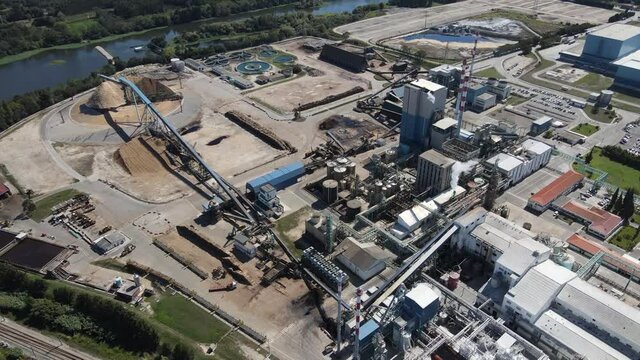 Aerial view of a paper production factory, drone moving forwards over the factory buildings. 4K, 60fps.