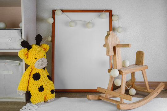 Mockup of the picture in the children's room. wooden horse and knitted toys. The interior of the nursery in beige colors.