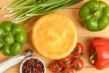 Tasty vegetable pot pie and ingredients on wooden background