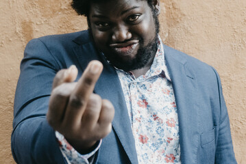 Shallow focus of a black man showing a middle finger