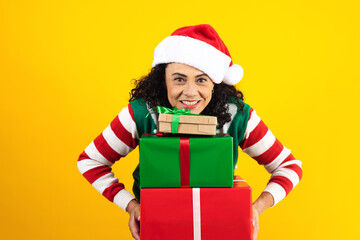 Portrait of Latin senior woman holding Christmas gift box on a yellow background in Mexico latin america	
