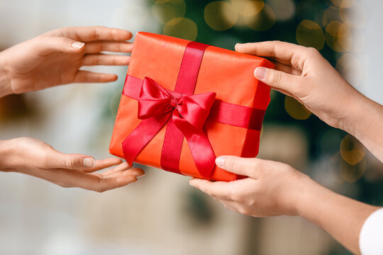 Women with red gift box at home on Christmas eve, closeup