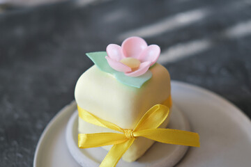 top view of mini cake decorated with edible flowera ns leaves made of rice paper. sweet treat for...